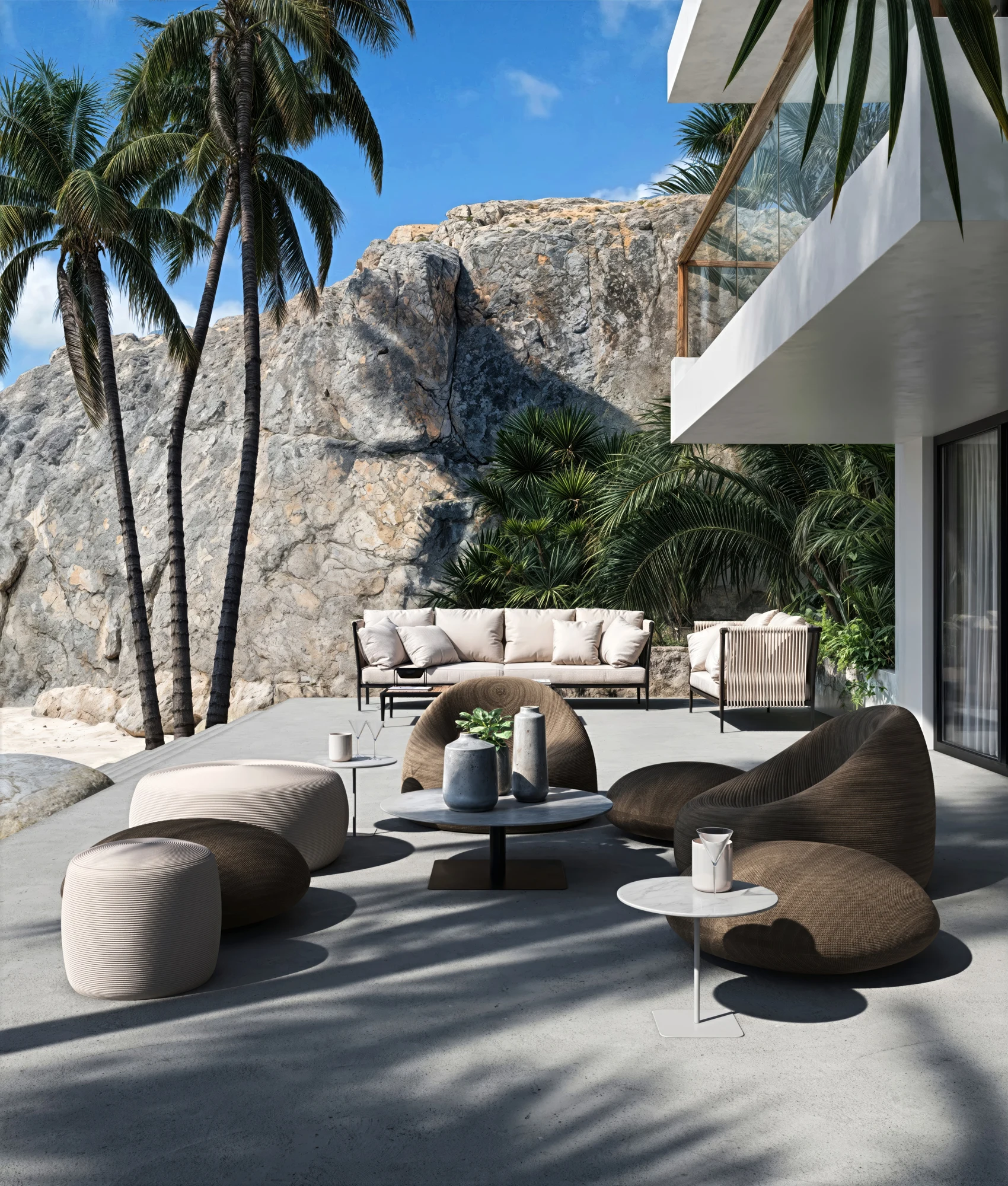 Villa terrace with sculptural seating, palm shadows and a natural rock backdrop